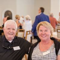 Two guests sitting at a table smiling at Naples 2019